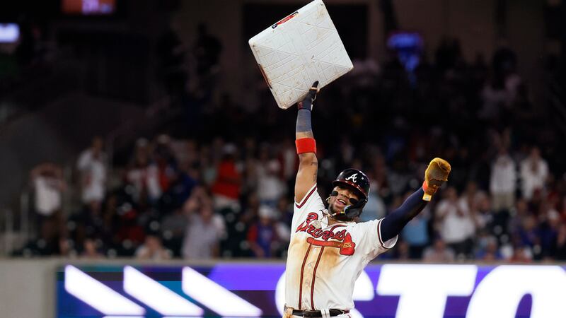 Ronald Acuña Jr. (13), de los Bravos de Atlanta, sostiene la almohadilla en lo alto después de...